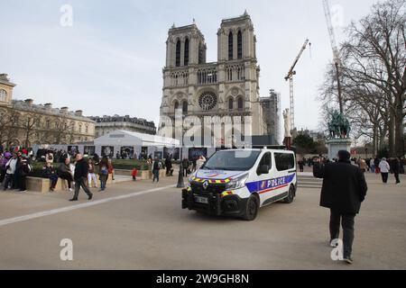 Paris, Frankreich. Dezember 2023. Eine allgemeine Ansicht zeigt, dass ein Polizeiauto geparkt ist und Touristen in der Nähe des Baus der Kathedrale Notre-Dame im Winter am 27. Dezember 2023 in Paris, Frankreich, genießen. Die Arbeiter der Kathedrale Notre-Dame stützen das zerbrechliche Gebäude nach einem verheerenden Brand im 15. April 2019 weiter. (Foto von Paulo Amorim/SIPA USA) Credit: SIPA USA/Alamy Live News Stockfoto