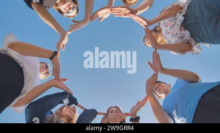 Schulfreunde bilden einen großen Kreis mit ihren Händen. Stockfoto