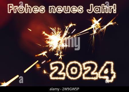 28. Dezember 2023: Happy New Year 2024 Schriftzug mit Funkenschrift vor einer Frau die eine Wunderkerze in der Hand hält FOTOMONTAGE in der Hand *** Frohes neues Jahr 2024 Schriftzug mit Funkenschrift vor einer Frau die eine Wunderkerze in der Hand hält FOTOMONTAGE Stockfoto