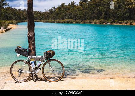 Ein Schotterrad parkt an einem Baum entlang des Munda Biddi Trail, einem 1000 km langen Radweg zwischen Perth und Albany in Westaustralien. Stockfoto