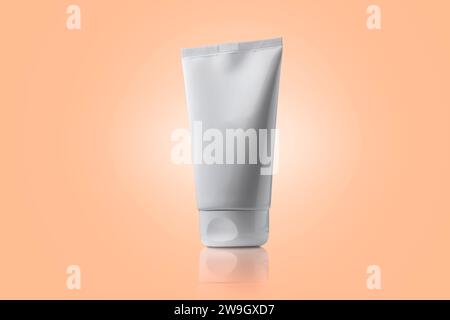 Weiße Tube Kosmetikcreme ohne Marke auf Peach Fuzz Hintergrund. Hautpflege. Verpackung für Branding mit Kopierraum. Kosmetisches Mittel. Stockfoto