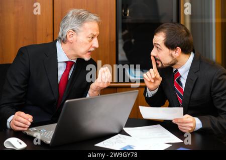 Zwei verärgerte Geschäftspartner streiten sich im Büro bei einem Meeting. Stockfoto