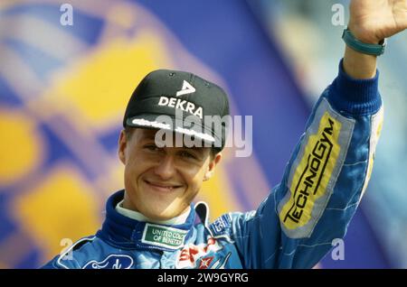 firo: Formel 1, Saison 1994 Sport, Motorsport, Formel 1, Archiv, Team Benetton (1991–1995), in Hockenheim Michael Schumacher, Deutschland, war von 1991 bis 2006 und von 2010 bis 2012 Formel-1-Fahrer, Schumacher wurde siebenmal siebter, Formel-1-Weltmeister, deutscher Nationalheld, brachte Formel 1 nach Deutschland, einer der größten Deutschen Michael Schumacher, Halbfigur, Geste Stockfoto