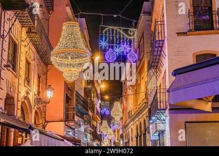 Sevilla, Spanien - 16. Dezember 2023: Weihnachtsbeleuchtung in der Sierpes Street in Form eines goldenen Kristallleuchters im Empire-Stil in Sevilla Stockfoto