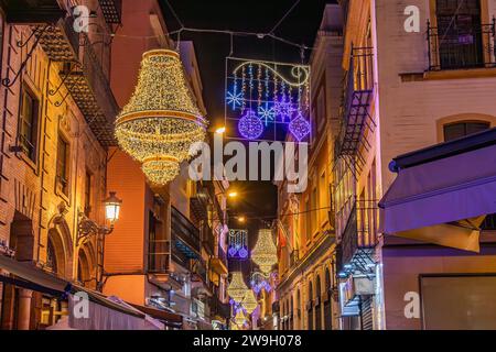 Sevilla, Spanien - 16. Dezember 2023: Weihnachtsbeleuchtung in der Sierpes Street in Form eines goldenen Kristallleuchters im Empire-Stil in Sevilla Stockfoto