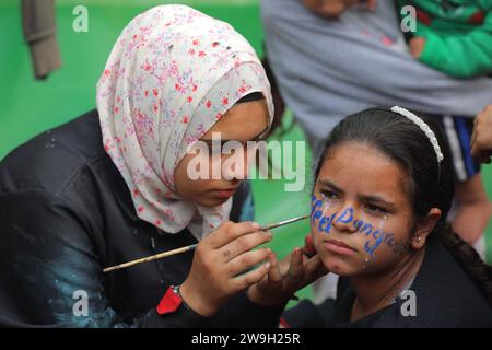 Die palästinensische Künstlerin Menna Allah Hamouda, 20 Jahre alt, zeichnet 2024 und Ausdrücke, die ein Ende des Krieges fordern die Gesichter der Vertriebenen Kinder palästinensische Künstlerin Menna Allah Hamouda, 20 Jahre alt. 2024 und Ausdrücke, die ein Ende des Krieges gegen die Gesichter der Vertriebenen fordern, vor den Neujahrsfeiern in einer UNRWA-Schule in Deir Balah im zentralen Gazastreifen am 28. Dezember 2023. Foto: Omar Ashtawy apaimages Dair El-Balah Gazastreifen Palästinensische Gebiete 271223 Dair El-Balah OSH 0047 Copyright: XapaimagesxOmarxAshtawyxapaimagesx Stockfoto