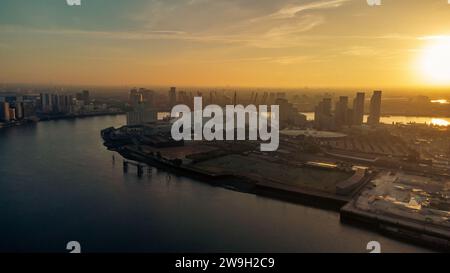 Bild eines atemberaubenden Sonnenuntergangs über einer geschäftigen Metropole mit einem ruhigen Gewässer im Vordergrund Stockfoto