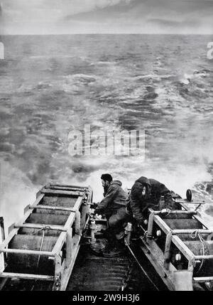 Besatzung auf einem alliierten Zerstörer, der sich darauf vorbereitet, Tiefenladungen für einen Zerstörer abzuwerfen, während er im Februar 1943 einen Atlantikkonvoi eskortiert. Sie waren Teil der Anti-U-Boot-Maßnahmen gegen die Rudel deutscher U-Boote während des Zweiten Weltkriegs. Stockfoto