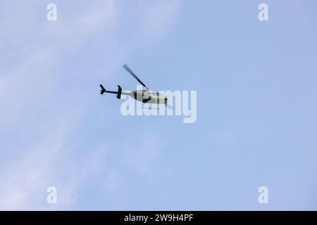 Ein Hubschrauber ist an einem sonnigen Tag im Himmel Stockfoto