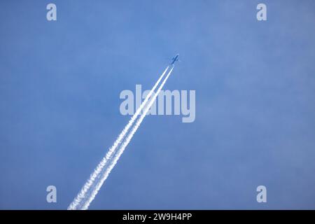 Jet-Flugzeug mit langer weißer Spur am blauen Himmel Stockfoto