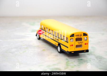 Amerikanischer Minibus in gelber Standardfarbe mit Stoppschild an der Seite. Rückansicht Stockfoto