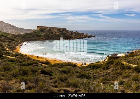 Għajn Tuffieħa Bucht. Strand mit dunklem Sand, beliebt zum Surfen und in einer Bucht, die von Hügeln umgeben ist, mit einem Küstenpfad in der Nähe von L-Imġarr, Malta Stockfoto