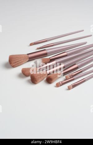 Set mit Make-up-Bürsten, verteilt auf weiße Tischplatte, verschiedene Formen und Größen von wichtigen Kosmetikwerkzeugen für bestimmte Zwecke, selektiv für Stockfoto