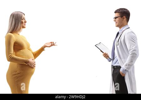 Profilaufnahme einer schwangeren Frau in einem gelben Kleid, die mit einem Arzt spricht, isoliert auf weißem Hintergrund Stockfoto