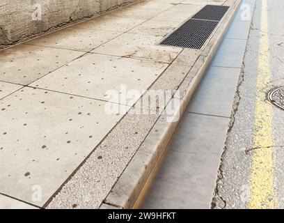 Ein Abschnitt einer abgenutzten und schmuddeligen leeren Straße, gepflasterter Bürgersteig und schwarze Ziegelwand – 3D-Rendering Stockfoto