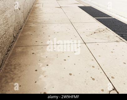 Ein Abschnitt einer abgenutzten und schmuddeligen leeren Straße, gepflasterter Bürgersteig und schwarze Ziegelwand – 3D-Rendering Stockfoto