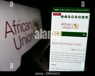 Person, die ein Smartphone hält, mit der Webseite der kontinentalen Organisation African Union (AU) vor dem Logo. Konzentrieren Sie sich auf die Mitte des Telefondisplays. Stockfoto