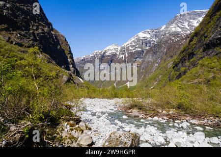 Klares Wasser aus Gletscherschmelzwasser vom Kjenndalsbreen-Gletscher vorbei an schneebedeckten Bergen im Lovatnet-Tal. Alt, Norwegen Stockfoto