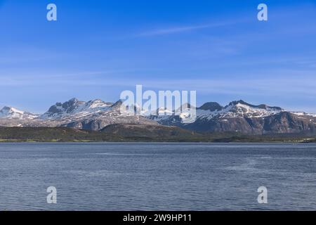 Sommerblick auf die schneebedeckten Berge im Saltfjord unter blauem Himmel in der Nähe von Bodo im Lofoten-Archipel in Norwegen Stockfoto