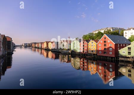 Blick auf den Sonnenuntergang über die Nidelva mit berühmten Holzhäusern am Ufer an einem Sommerabend in Trondheim, Norwegen Stockfoto