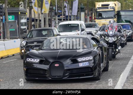 Paris, Frankreich - Black Bugatti Chiron Sport fährt auf der Champs Elysée mitten im Verkehr. Stockfoto