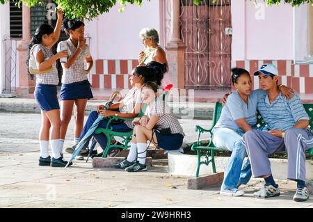 Ein einheimisches Paar umarmt die Bank und Studenten in Uniform. Stockfoto