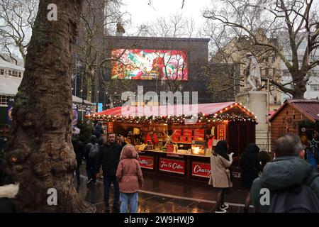 Die Besucher genossen den Weihnachtsmarkt mit seinen Ständen am Leicester Square trotz des Regens. London Großbritannien Stockfoto