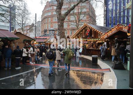 Die Besucher genossen den Weihnachtsmarkt mit seinen Ständen am Leicester Square trotz des Regens. London Großbritannien Stockfoto