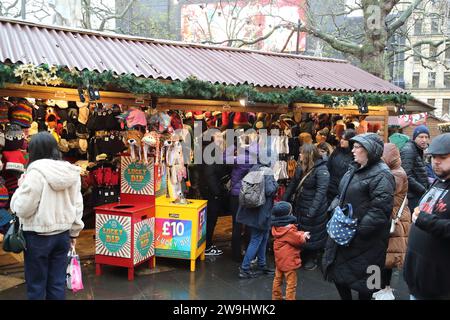 Die Besucher genossen den Weihnachtsmarkt mit seinen Ständen am Leicester Square trotz des Regens. London Großbritannien Stockfoto