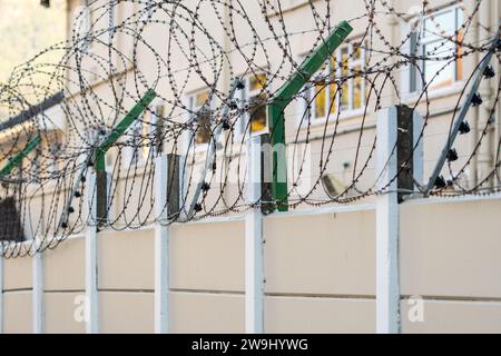 Elektrischer Zaun an einer Umrandungswand zusammen mit Stacheldraht oder Stacheldraht, um ein privates Grundstückskonzept für Sicherheit und Sicherheit in Südafrika zu gewährleisten Stockfoto