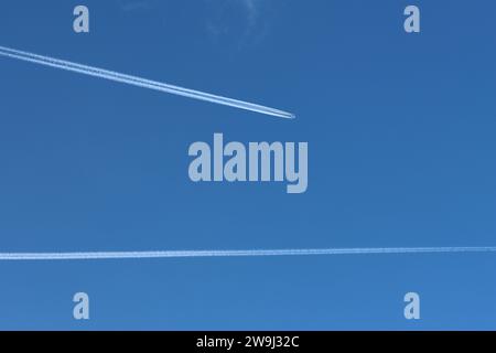 Flugzeug mit Kondensstreifen am tiefblauen Himmel Stockfoto