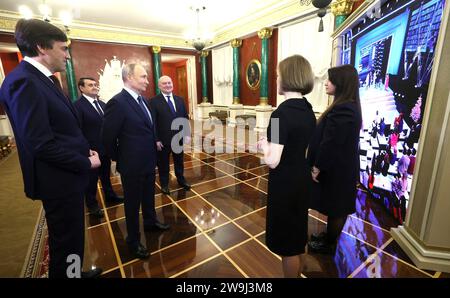 Moskau, Russland. Dezember 2023. Der russische Präsident Wladimir Putin, Mitte, zusammen mit dem Bildungsminister Sergej Krawzow, links, und Vorsitzender der Kommission des Staatsrats für Bildung, Gouverneur von Sewastopol Michail Razwozhajew, rechts, während einer Rundfahrt durch eine Ausstellung, die den wichtigsten Ereignissen des kommenden Jahres der Lehrer und Mentoren im Kreml gewidmet ist, am 27. Dezember 2023 in Moskau, Russland. Quelle: Gavriil Grigorov/Kreml Pool/Alamy Live News Stockfoto