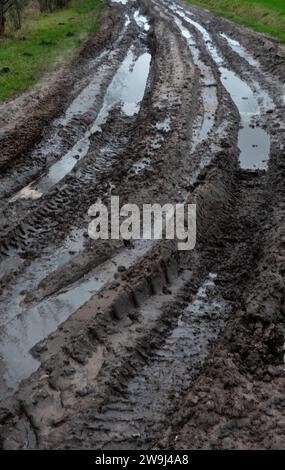 Übermäßiger Regen, schlammiger Weg voller Traktorketten Stockfoto