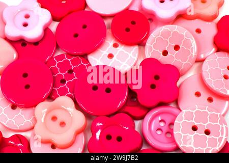 Nahaufnahme der rosafarbenen und roten Kunststoffknöpfe. Craft-Konzept. Hintergründe. Stockfoto