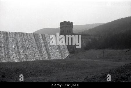 1970er Jahre, historisch, überfließt Wasser am Derwent Reservoir im Peak District, England, Großbritannien, wobei das Bild auch den Turm an der neogotischen Massivmauermauer zeigt. Die Bauarbeiten begannen 1902 und wurden 1916 abgeschlossen. Der Stausee war einer der Orte, an denen Piloten die für die Operation Chastise, die berühmten Dam Busters Razzien des 2. Weltkriegs, erforderlichen Flüge übten. Stockfoto
