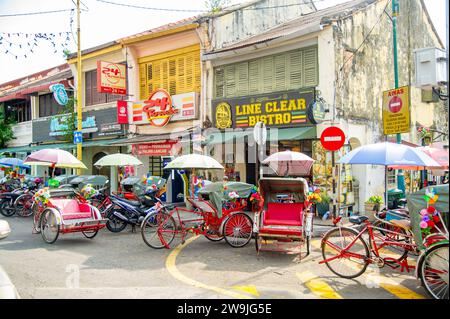 21 . - 2023 - Penang Malaysia - viele Tuk Tuk-Fahrzeuge mit roten Sitzen warten auf Kunden . Stockfoto