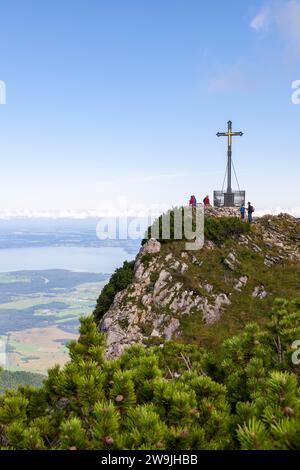 Gipfelkreuz auf dem Hochfelln, im Hintergrund und am Chiemsee, Menschen, Wanderer, Chiemgauer Alpen, Oberbayern, Bayern, Deutschland Stockfoto