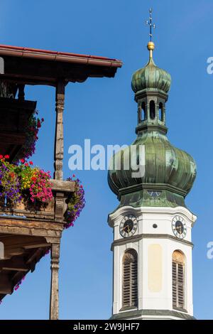 Kirchturm der Pfarrkirche St. Pankratius, Holzbalkon mit Sommerblumen, Reit im Winkl, Oberbayern, Bayern, Deutschland Stockfoto