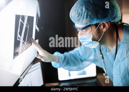 Der Chirurg untersucht Fluorographiebilder auf einem Monitor im OP einer Arztpraxis Stockfoto