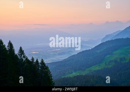 Sonnenaufgang über nebeliger Berglandschaft mit Wald im Vordergrund, Gurnigelpass, Thunersee, Kanton Bern, Schweiz Stockfoto