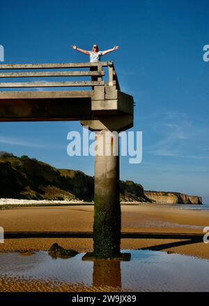 Eine Dame am Steg, die sich auf der Welt fühlt, an der Küste der Normandie, Frankreich, Europa Stockfoto