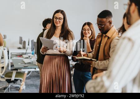 Erfolgreiches multiethnisches Geschäftsteam, das an Marktanalysen und Finanzplanung mitarbeitet. Stockfoto