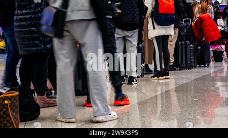 Fluggäste, die sich für einen verspäteten Flug am Flughafen anschlangen, da der Urlaubsverkehr mit langen Warteschlangen und mehreren stornierten Flügen zu kämpfen hatte Stockfoto