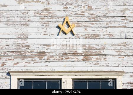Fall City, WA, USA - 21. September 2023; Freimaurerplatz und Zirkelsymbol auf alten, abgenutzten weißen, verwundeten Gebäudewänden Stockfoto