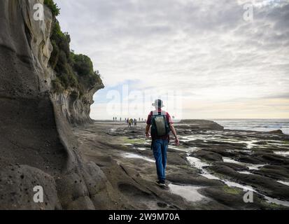 Im Sommer spazieren und spielen die Leute am Muriwai Beach. Auckland. Stockfoto