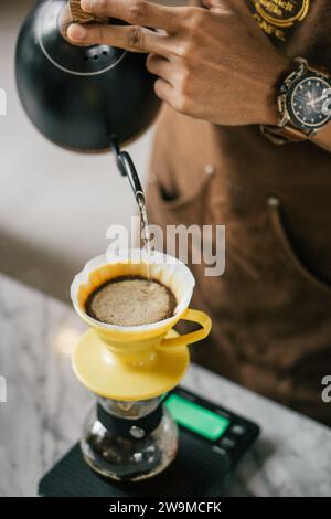 Die Kaffeemaschine befindet sich mitten im Brühritual und entfaltet anmutig das reiche Aroma frisch gemahlener Kaffeebohnen. Stockfoto