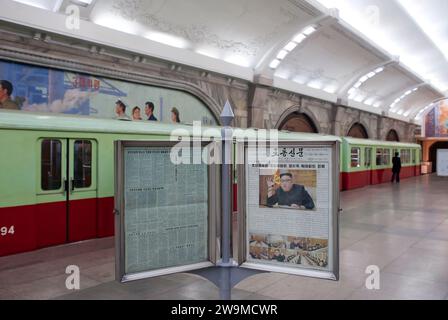 Eine Zeitung, die ein Bild von Kim Jong-un zeigt, das Pendlern auf dem Bahnsteig der U-Bahn-Station Puhung in Pjöngjang, Nordkorea, zur Verfügung steht Stockfoto