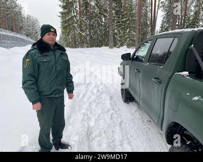 Silene, Lettland. Dezember 2023. Der lettische Grenzschutzbeamte Wladimirs Sersts steht neben seinem Fahrzeug an der lettisch-belarussischen Grenze. Lettland hat eine etwa 172 Kilometer lange Grenze zu Russlands engstem Verbündeten Belarus, das Teil der EU-Außengrenze ist. (An dpa "Lettland: Zaun an der Grenze zu Belarus nähert sich der Fertigstellung") Credit: Alexander Welscher/dpa/Alamy Live News Stockfoto