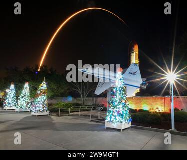 Zwei Stunden und vierundfünfzig Minuten nach dem Start der SpaceX Falcon Heavy überquert eine SpaceX Falcon 9 Rakete den Rocket Tree Trail und ein NASA T-38 Flugzeug im Kennedy Space Center Visitors Center im Kennedy Space Center, Florida am Donnerstag, den 28. Dezember. 2023. Der Rocket Tree Trail, gesponsert von L3 Harris Technologies, wurde zur Feier der Weihnachtszeit im Center platziert. SpaceX startete 23 Starlink-Satelliten der zweiten Generation in den Orbit. Foto: Joe Marino/UPI Credit: UPI/Alamy Live News Stockfoto