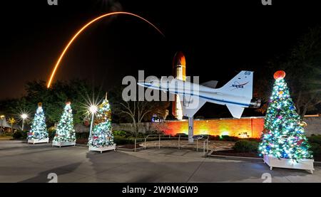 Zwei Stunden und vierundfünfzig Minuten nach dem Start der SpaceX Falcon Heavy überquert eine SpaceX Falcon 9 Rakete den Rocket Tree Trail und ein NASA T-38 Flugzeug im Kennedy Space Center Visitors Center im Kennedy Space Center, Florida am Donnerstag, den 28. Dezember. 2023. Der Rocket Tree Trail, gesponsert von L3 Harris Technologies, wurde zur Feier der Weihnachtszeit im Center platziert. SpaceX startete 23 Starlink-Satelliten der zweiten Generation in den Orbit. Foto: Joe Marino/UPI Credit: UPI/Alamy Live News Stockfoto